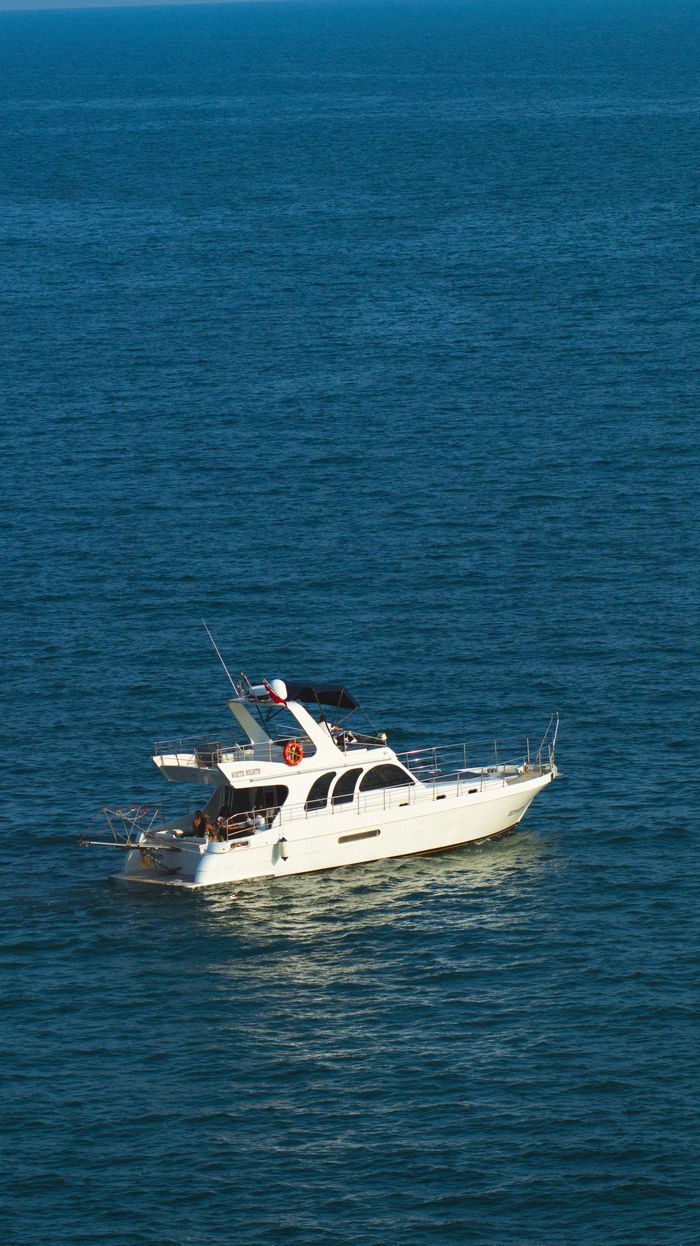 creative-01 A stunning white yacht sails on the tranquil blue sea near Antalya, Türkiye, epitomizing luxury and travel.