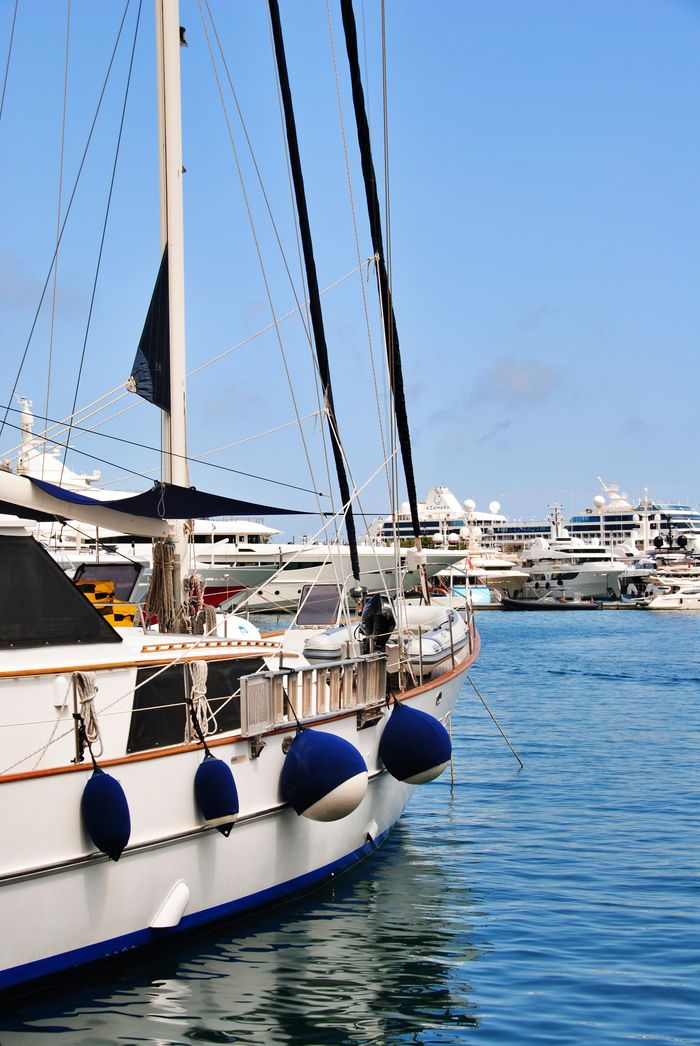 creative-03 A scenic view of luxury yachts in Monacos marina under a clear blue sky.