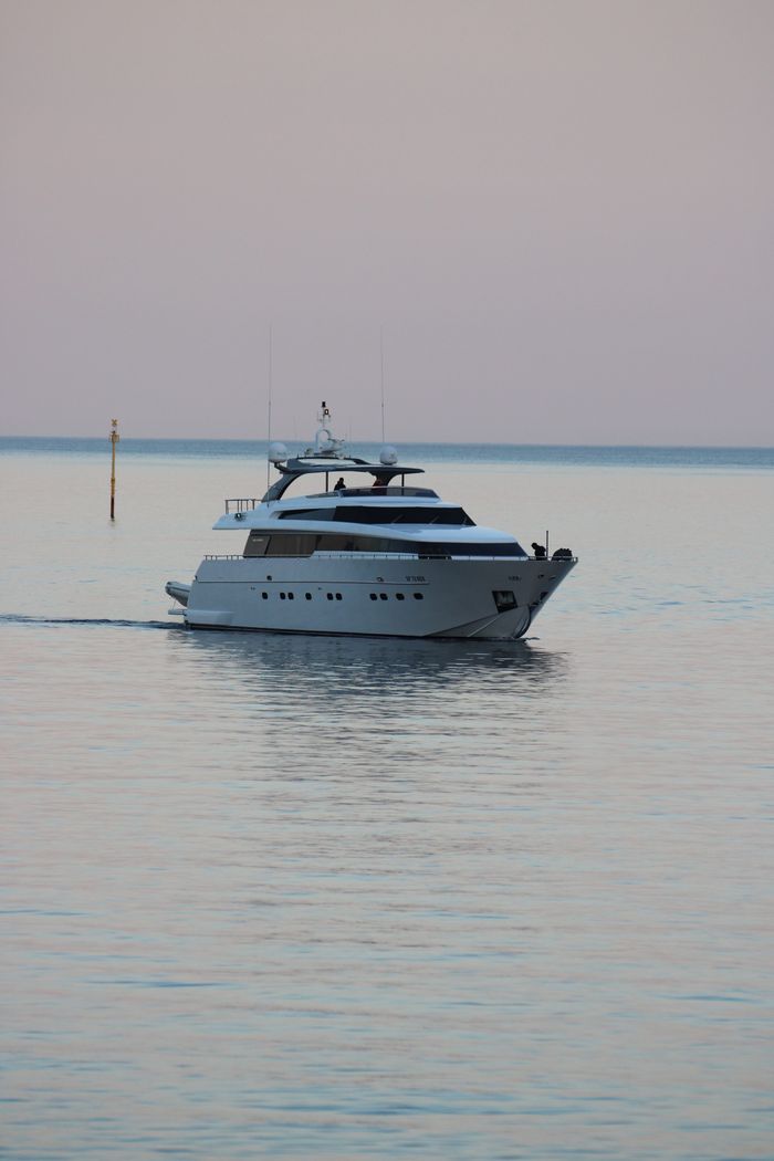 creative-03 Elegant yacht cruises on serene waters near Portofino, Italy, during a tranquil sunset.