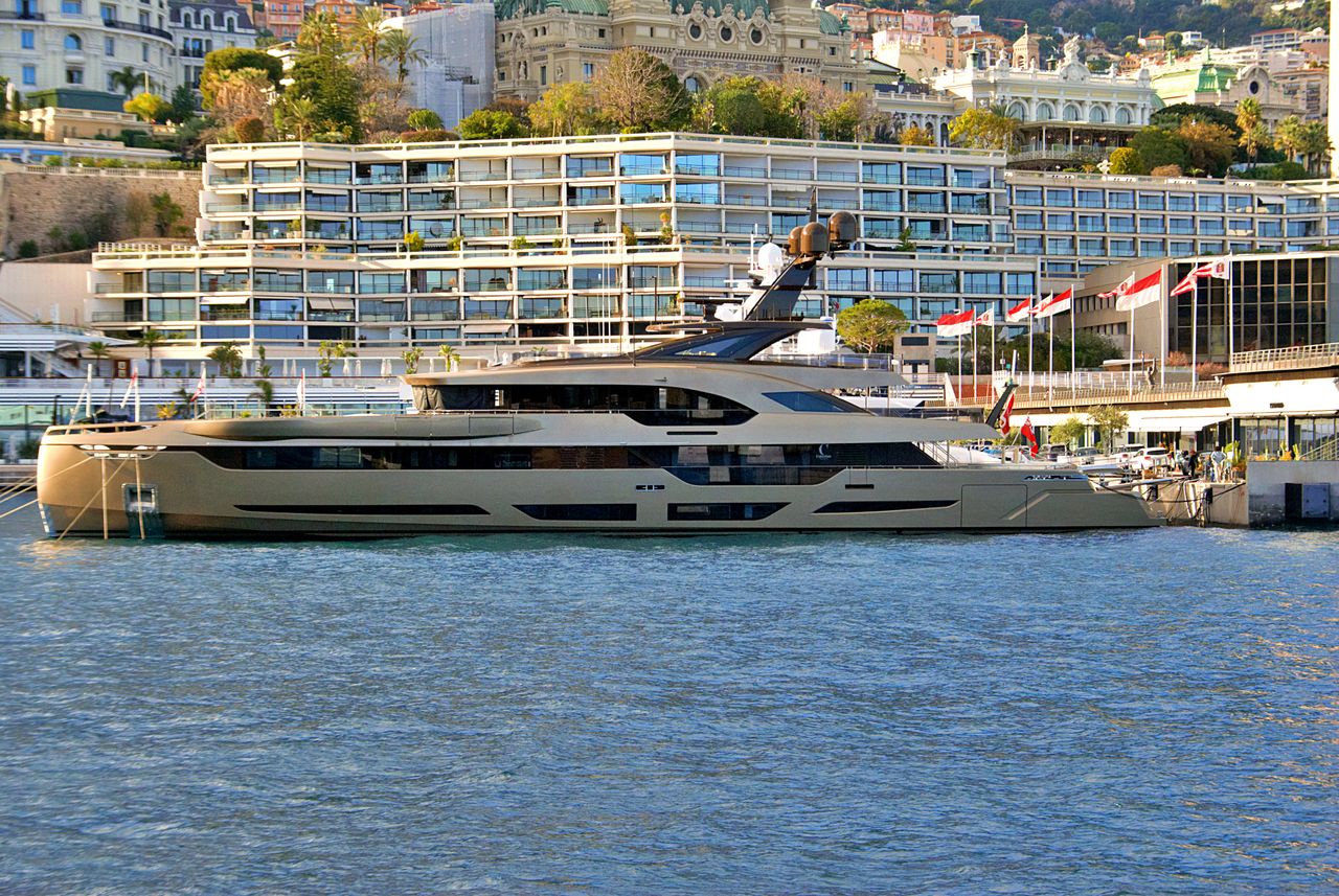 brand-02 A luxury yacht moored at the picturesque Monaco harbor with modern waterfront architecture.
